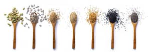 Seven wooden ladles with various healthy seeds
