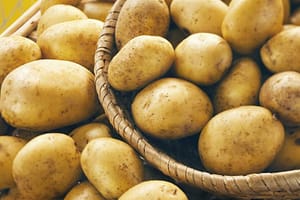 Fresh potatoes on wooden basket