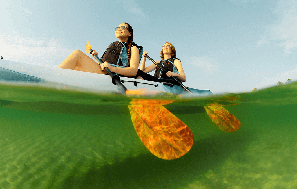 friends kayaking on clear water