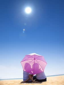 couple under the heat of sunlight in umbrella