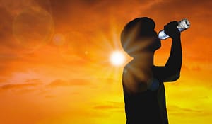 silhouette man drinking bottled water on a hot weather