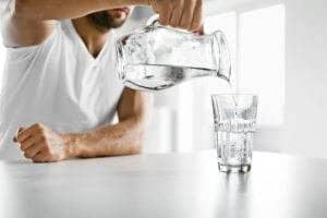 a person pouring water in a glass