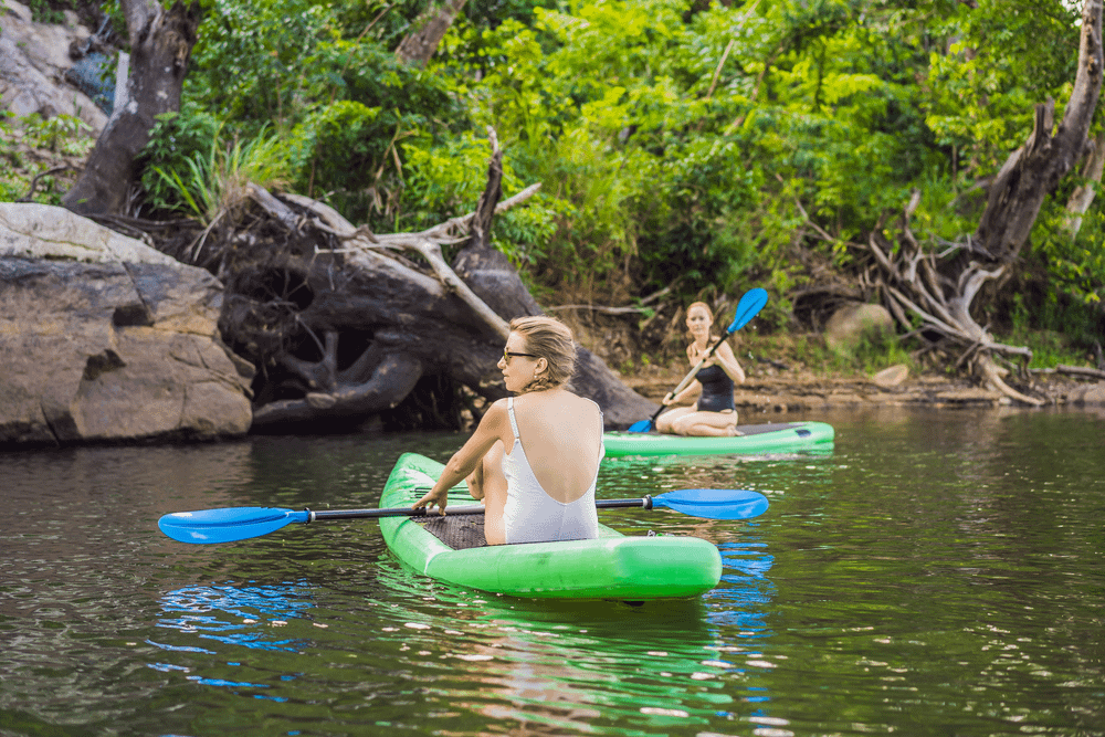 Two people paddling single kayaks